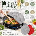 フライパンの上に広げて使う、グレーとレッドの折りたたみシリコーン油はねガード